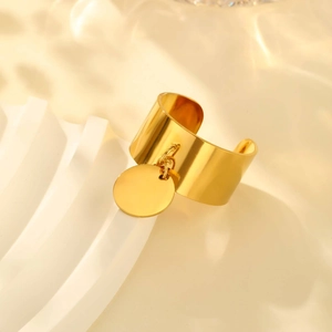 Detailed view of a gold-plated stainless steel ring with a round pendant on a wavy stand