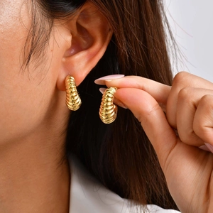 Golden twisted croissant hoop earrings in stainless steel with a high-gloss finish