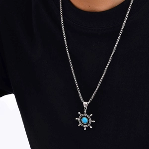 Detailed view of nautical ship wheel pendant with turquoise stone on black background
