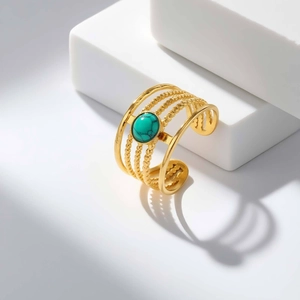 Macro detail of bohemian gold multi-layer ring with round turquoise and beaded texture
