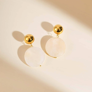 Boucles d'oreilles boules dorées avec disques en résine blanche vus de dessus