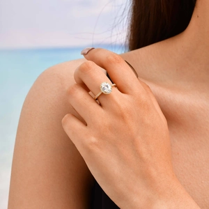 Macro detail of gold-plated halo ring with green zircon and side-stone setting