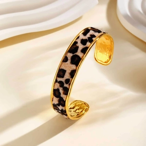 Detail view of golden stainless steel open cuff bracelet with leopard print texture inlay