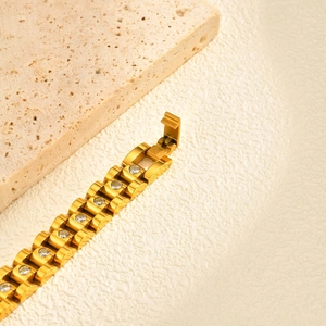 Macro detail of gold stainless steel watchband bracelet with sparkling zircon stones