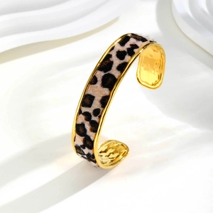Detail view of gold leopard print cuff bracelet featuring a unique hammered inner metal texture