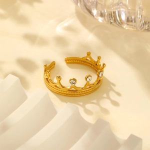 Detailed view of 18K gold plated crown ring with zircon stones on a white stand