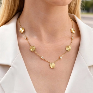 Detail of gold flower necklace with five petal charms and sparkling zircon stones