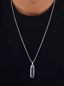 Detail einer Herren-Halskette mit schwarzem rechteckigem Anhänger an einem Model getragen