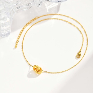 Collier élégant à double anneau doré avec texture géométrique sur fond blanc épuré