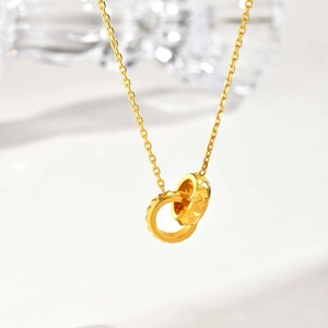 Collier doré avec deux anneaux entrelacés et relief géométrique sur chaîne fine