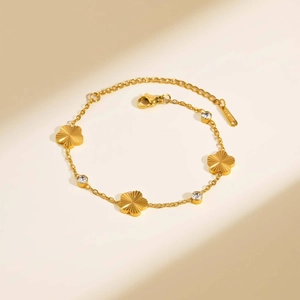 Golden stainless steel bracelet featuring five-petal flower charms and zircon stones