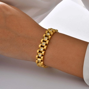 Elegant gold watch-band style bracelet with sparkling cubic zirconia on female wrist