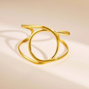 Macro shot of gold-plated stainless steel double-layered geometric bangle with wavy lines