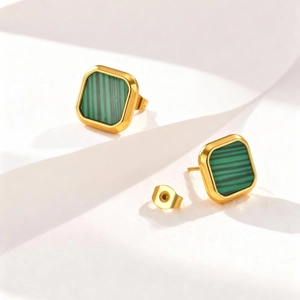 Macro detail of gold square earrings with green malachite inlay on geometric background