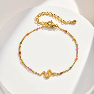 Detail of gold snake bracelet with colorful beads and lobster clasp on white tray