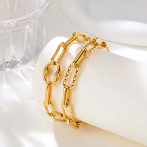 Dettaglio macro del bracciale a maglie in acciaio dorato con anelli intrecciati su base