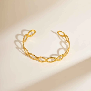 Detailed close-up of 18K gold-plated twisted rope open bangle with metallic luster