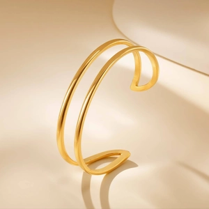 Minimalist double layer geometric open bangle in gold finish with polished metal surface