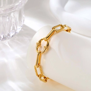 Dettaglio macro di bracciale a catena dorata con anelli strutturati stile equestre