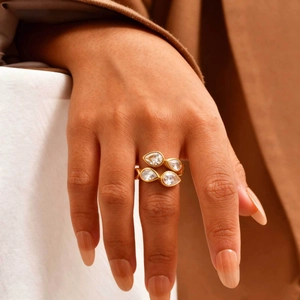 Close-up of gold wrap ring featuring four pear-cut cubic zirconia stones on model hand