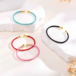 Detail of colorful braided steel wire C-shaped open bracelets with gold metal end caps