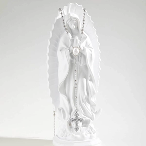 Détail d'un chapelet en métal argenté avec icône sacrée et crucifix sur une statue