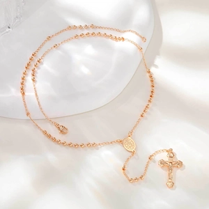 Vue détaillée d'un collier chapelet doré avec médaille de la Vierge et croix de Jésus
