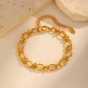 Macro detail of gold-plated linked bracelet with K18 engraved tag and lobster clasp