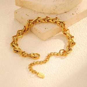Close-up of golden irregular chain bracelet with K18 engraving and lobster clasp