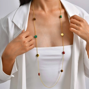 Détail du collier bohème doré avec perles de malachite colorées et œil de tigre