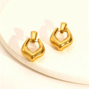 Close-up of geometric 18K gold hollow earrings with high-polish mirror finish