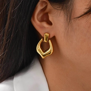 Close-up of a model wearing minimalist 18K gold hollow geometric hoop earrings