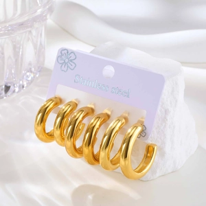 Three pairs of elegant golden C-shaped stainless steel hoop earrings on a display card