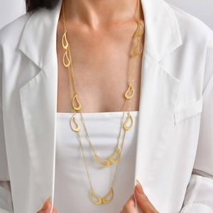 Détail d'un collier long doré à double épaisseur avec pendentifs paisley sur un mannequin