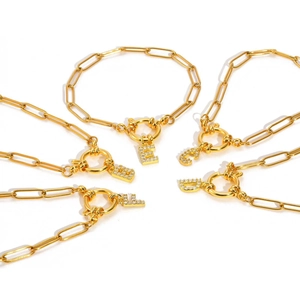 Gouden paperclip armband met kristallen letterhanger en handige toggle sluiting