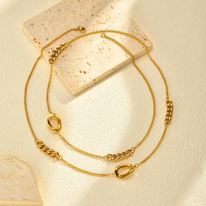 Détail d'un collier doré avec mélange de maillons fins et éléments de chaîne gourmette