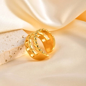 Dettaglio ravvicinato di anello dorato regolabile con catena a spirale e texture lisce