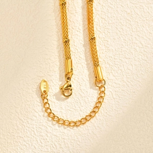 Detailed macro of gold mesh chain link with K18 gold hallmark and lobster clasp closure