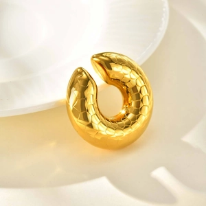 Detailed close-up of 18K gold hollow C-shaped ear cuff with textured scale pattern