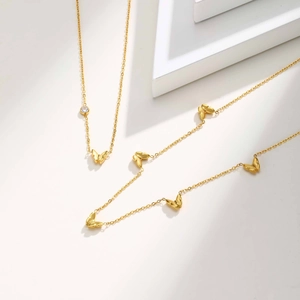 Collier papillon doré élégant avec pendentif en zircon sur présentoir minimaliste
