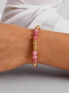 Detail of pink crystal beaded bracelet with gold metal accents on female wrist