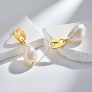 Boucles d'oreilles minimalistes en acier doré avec perles baroques sur socle en pierre