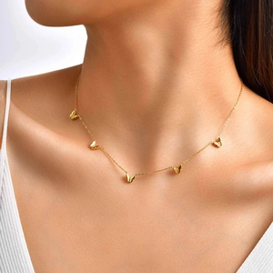 Collier papillon doré élégant pour femme avec cinq breloques délicates sur chaîne