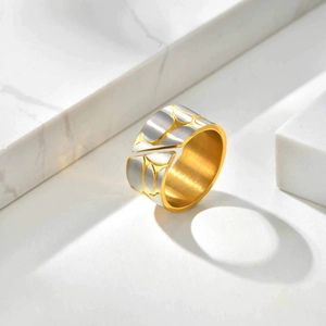 Macro detail of bicolored stainless steel ring with pebble texture and gold interior