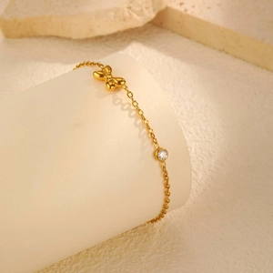 Détail de la chevillère papillon plaquée or 18K avec zircon sur support d'affichage
