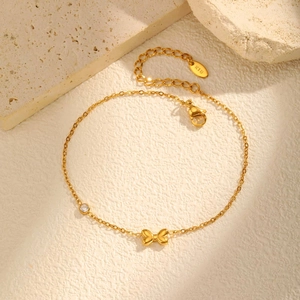 Détail de la chaîne de cheville en or 18K avec nœud et zircon sur pierre naturelle