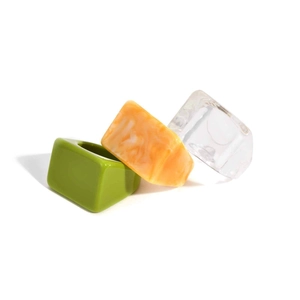 Three-piece geometric resin ring set in transparent, marbled amber, and lime green styles
