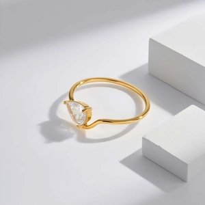 Detail view of pear-cut zircon on wave-designed 18K gold plated stainless steel ring