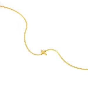 Detail einer minimalistischen goldenen Schlangenkette mit kleinem Kreuzanhänger