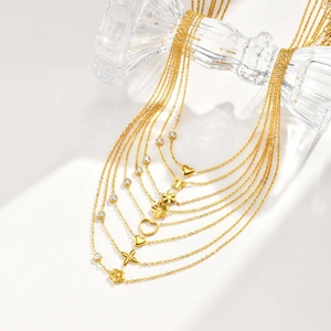 Detailansicht goldener Halsketten mit Blumen- Herz- und Schmetterlingsanhängern mit Zirkonia
